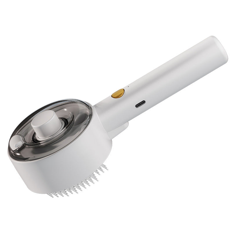 White spray pet grooming comb angled to show the round reservoir head, handle controls, and grooming pins.