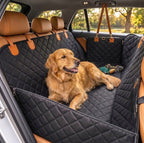 Golden retriever lying on a black quilted dog car seat hammock in a vehicle.
