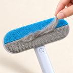 Close-up of collected pet hair being lifted from the textured brush surface.